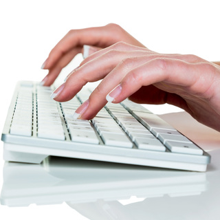 Eine Frau arbeitet in einem B?ro auf der Tastatur eines Computers